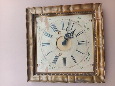 Wooden face clock framed in an art deco gold frame