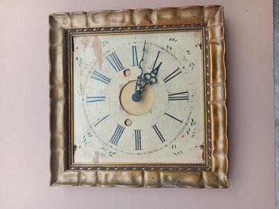 Wooden face clock framed in an art deco gold frame