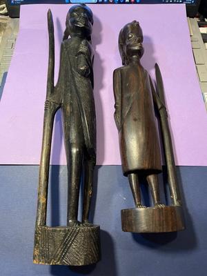 2 Vintage Ebony Hand Carved African Wood Statue Figurines w/Spears 12" & 15" in Good Preowned Condition as Pictured.