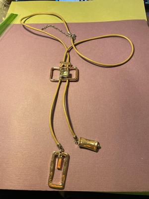 Modern Day Bolo Tie Gold-tone Necklace on a Beige/Creme Color Cord in VG Preowned Condition.