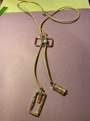 Modern Day Bolo Tie Gold-tone Necklace on a Beige/Creme Color Cord in VG Preowned Condition.