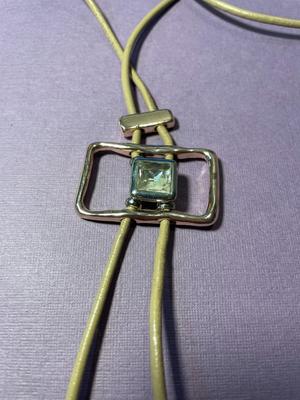 Modern Day Bolo Tie Gold-tone Necklace on a Beige/Creme Color Cord in VG Preowned Condition.