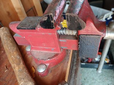 Small workbench mount vice with assortment of hammers