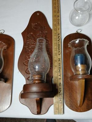 Three wooden wall hanging candle sconces with glass globes