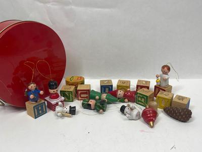 Sale Photo Thumbnail #617: 10 ornaments created bt attaching wooden baby blocks to wood figurines or other objects.  Also included is a small lidded box with miniature Guatemalan Worry Dolls. All inside a red, round tin.  Good condition, some of the blocks have come unglued from th