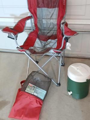 Mesh folding camp chair with carry bag and a green igloo drink cooler