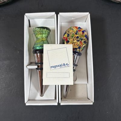 LOT 203: Arthur Court Grape Cluster Canister, Ragazzi & Co. Bottle Stoppers, Grape Cluster Bottle Coasters, Black Stemware w/Matching...