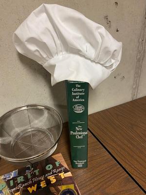 VARIETY OF COOKBOOK’S, A CHEF’S HAT AND KITCHEN GADGETS
