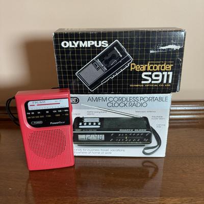 LOT 104: Transistor Radios, Sylvania Portable DVD Player, Olympus Pearlcorder, Am/Fm Cordless Portable Alarm Clock Radio