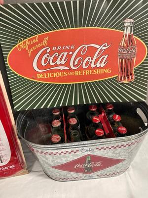 Coca-Cola sign, thermometer, bucket, and bottles