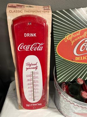 Coca-Cola sign, thermometer, bucket, and bottles
