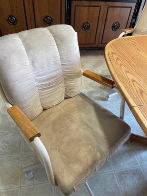 Oval oak dining room table with four rolling chairs