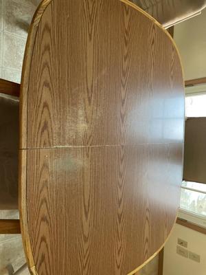 Oval oak dining room table with four rolling chairs