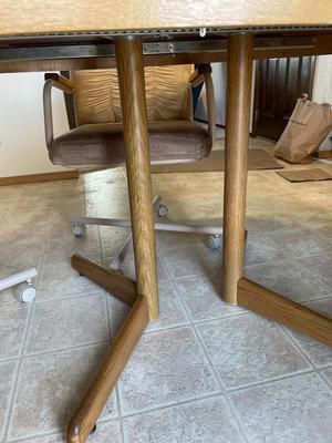 Oval oak dining room table with four rolling chairs