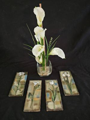 Faux cala lilies in a vase with four floral wall hanging plaques