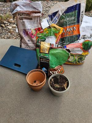 Variety of flowerpots, and partial bags of lawn car and fertilizer