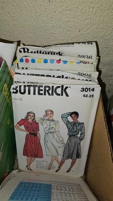 Box of sewing patterns, Singer sewing machine attachments, and assortment of other sewing needs