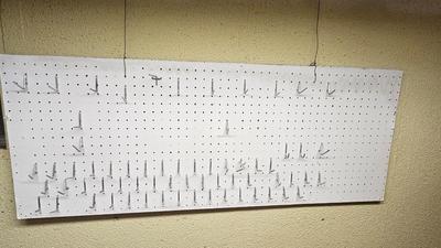 Pegboard with hardware and a nice free hanging shop light