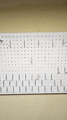 Pegboard with hardware and a nice free hanging shop light