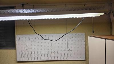 Pegboard with hardware and a nice free hanging shop light