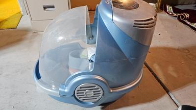 Cat litter box with air filter, toys, and food bowl
