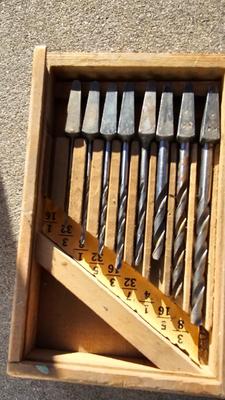 Vintage wood handled drill with drill bits and an old grease gun