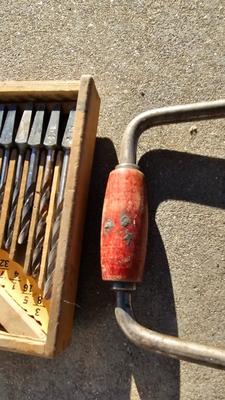 Vintage wood handled drill with drill bits and an old grease gun