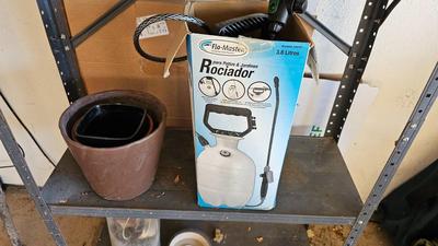 Metal shelf with planter pots weed sprayer, handcrafted plant rooters and more gardening items