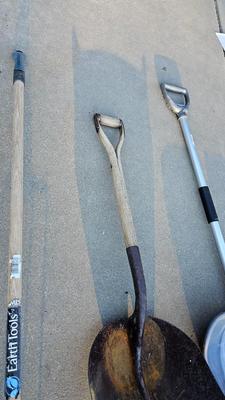 Snow shovels with garden tools and an axe