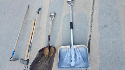 Snow shovels with garden tools and an axe