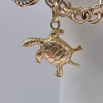 LOT 35: 14K Gold Charm Bracelet w/ 18K Corletto Blackamoor Pendant, 14K Carnelian Charm, 14K Handpainted Lady &Bead. 22.7gtw