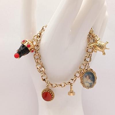 LOT 35: 14K Gold Charm Bracelet w/ 18K Corletto Blackamoor Pendant, 14K Carnelian Charm, 14K Handpainted Lady &Bead. 22.7gtw