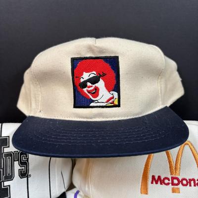 LOT 150: Vintage Ronald Mcdonald T-Shirt (qty 3, xl, xl, l), Hats (3) and a Lidded Plastic Coffee Mug