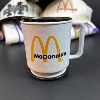 LOT 150: Vintage Ronald Mcdonald T-Shirt (qty 3, xl, xl, l), Hats (3) and a Lidded Plastic Coffee Mug