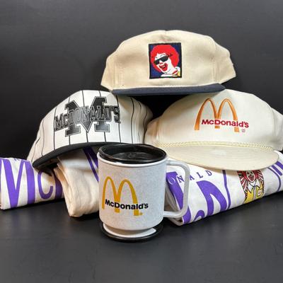 LOT 150: Vintage Ronald Mcdonald T-Shirt (qty 3, xl, xl, l), Hats (3) and a Lidded Plastic Coffee Mug