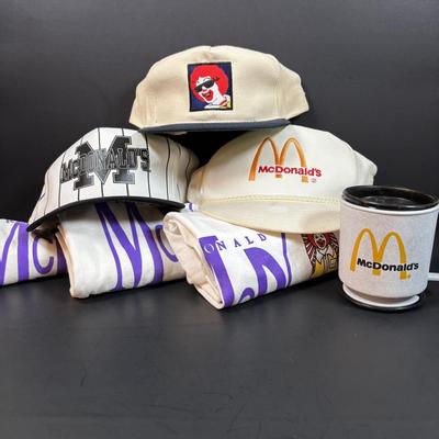 LOT 150: Vintage Ronald Mcdonald T-Shirt (qty 3, xl, xl, l), Hats (3) and a Lidded Plastic Coffee Mug