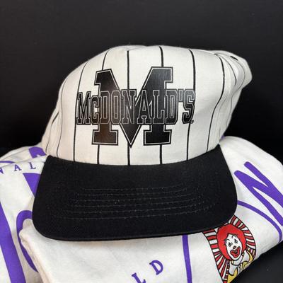 LOT 150: Vintage Ronald Mcdonald T-Shirt (qty 3, xl, xl, l), Hats (3) and a Lidded Plastic Coffee Mug