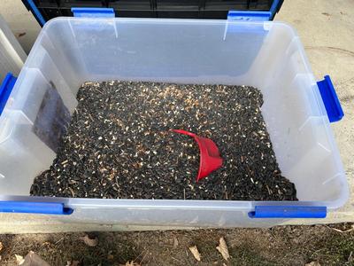 BIRD FEEDER WITH TOTE OF BIRD SEED AND HOSE HIDEAWAY