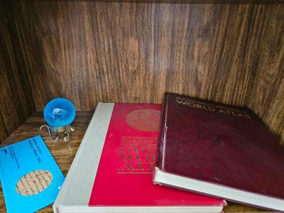 Vintage glass globe paper weight with stand and two World Atlas hardback books