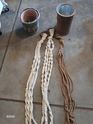 Two pottery flowerpots with three macramé plant hangers