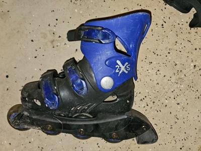 Sports bag with child's size rollerblades - Safety gear - and a few small golf clubs