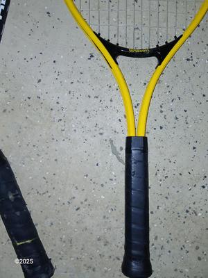 Three tennis racquets with a Wilson tennis racquet bag