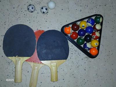 Racquets, paddles with pong balls and a small set of Pool balls