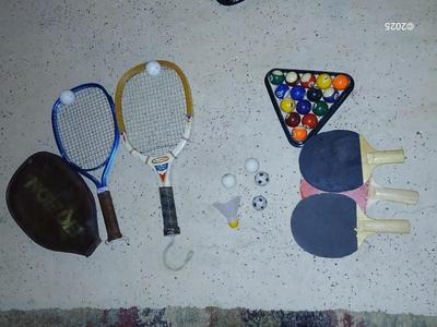 Racquets, paddles with pong balls and a small set of Pool balls