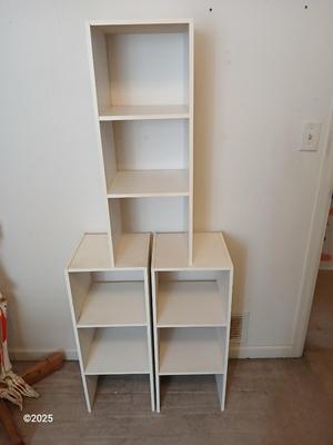 Three narrow white cubby shelves
