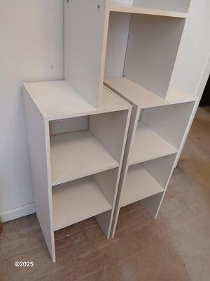 Three narrow white cubby shelves