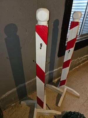 Two candy cane stripe posts with hooks and a box of Christmas light strands