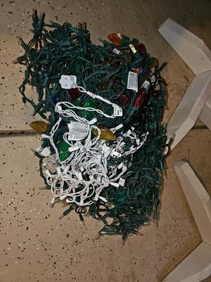 Two candy cane stripe posts with hooks and a box of Christmas light strands