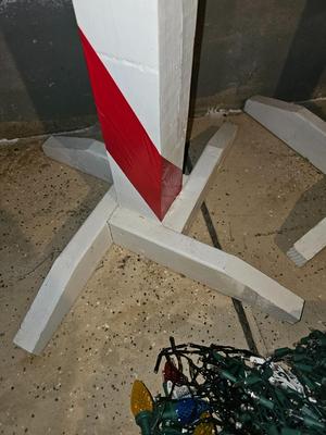 Two candy cane stripe posts with hooks and a box of Christmas light strands