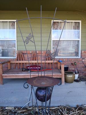 Neat handmade rustic plant stand with bowling ball center and a heavy metal Dragonfly Trellis